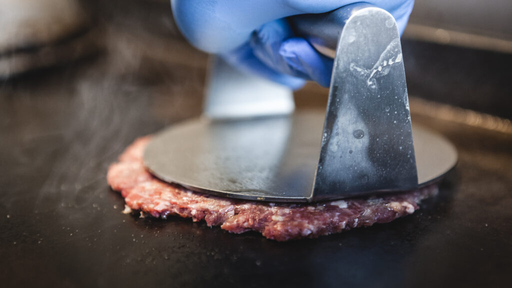 Smash burger being pressed on the grill